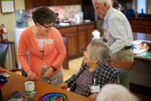 Caregiver talking with female senior over coffee
